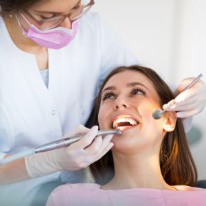 Dentist Performing Dental Cleaning for Client